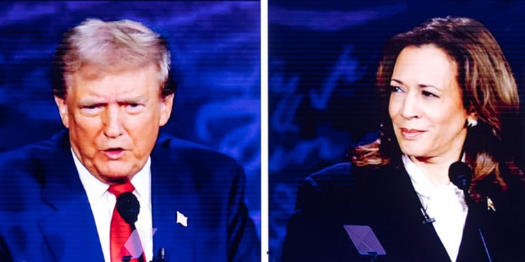 People react at the Mesa Convention Center while watching former President Donald J. Trump and Vice President Kamala Harris